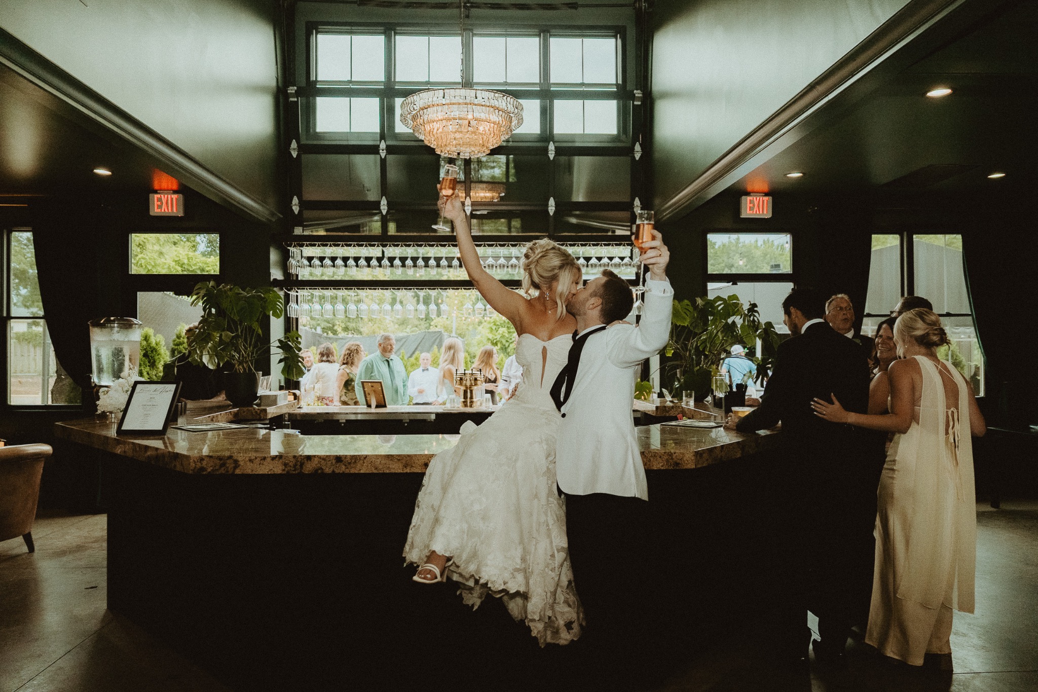 Newlyweds celebrating at a dark reception bar